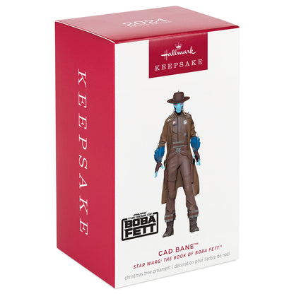 Star Wars themed Christmas ornament featuring the character Cad Bane from 'The Book of Boba Fett'. The ornament is packaged in a red and white gift box with 'Keepsake' branding.